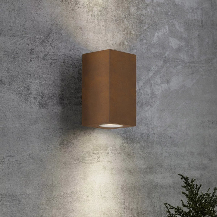 Buitenlamp cortenstaal up en downlighter sfeerbeeld, warme roestkleurige wandverlichting.